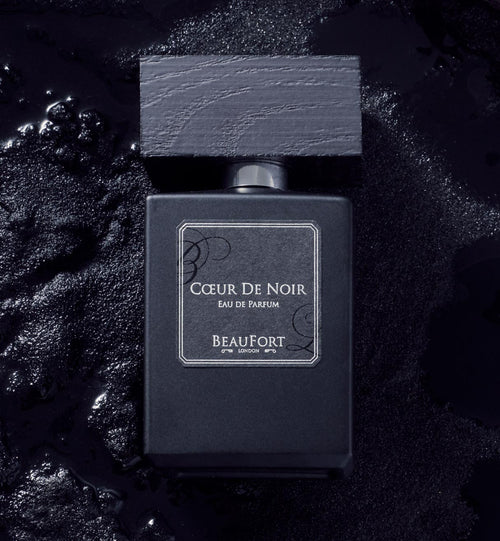 A bottle of BeauFort London's Coeur De Noir Eau De Parfum, sat on a bed of black Ink